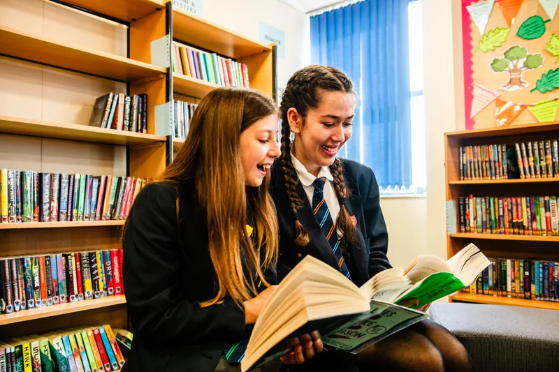 Two girls reading in school library
